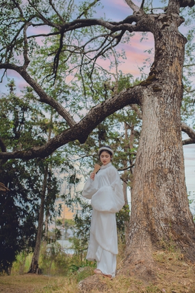 站在树下的白色奥黛美女摄影图片